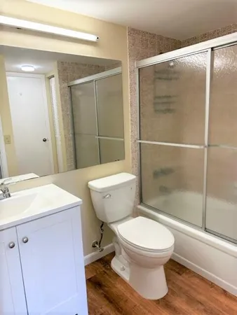 a bathroom with a sink a toilet a mirror and shower