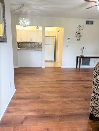 a view of a kitchen with wooden floor and a window