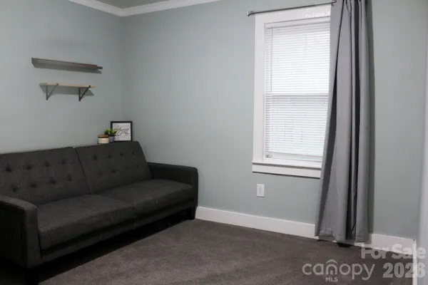 a view of a workspace room with furniture and a window