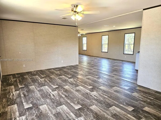 a view of a room with wooden floor and window