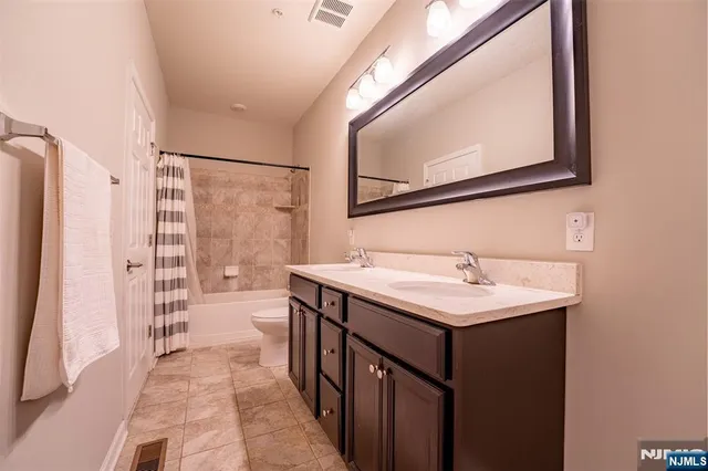 a bathroom with a sink a toilet a mirror and shower