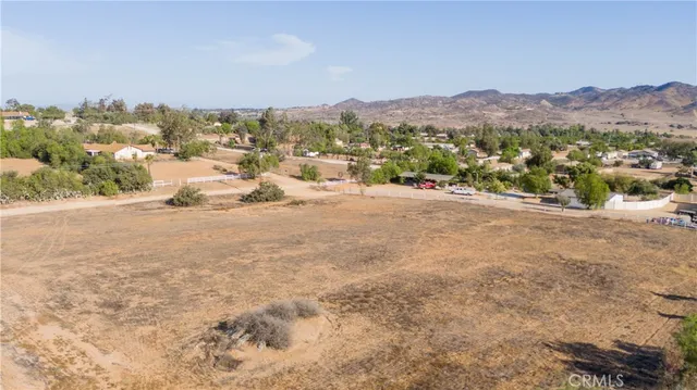 an aerial view of residential houses with outdoor space and trees
