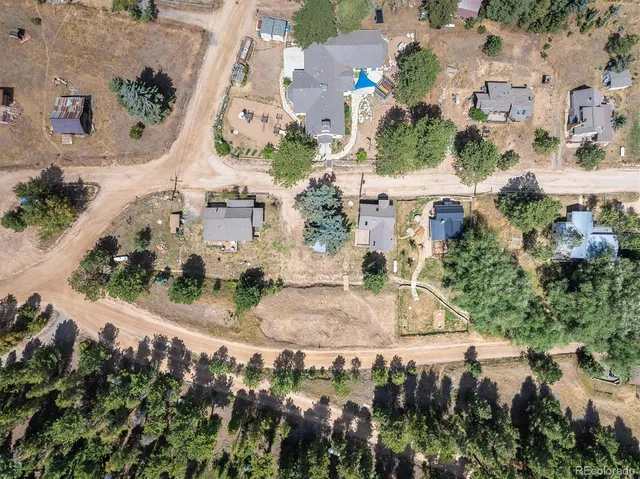 an aerial view of residential houses with outdoor space and trees