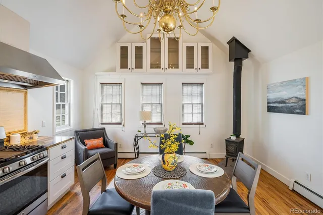 a view of a dining room with furniture a rug and wooden floor
