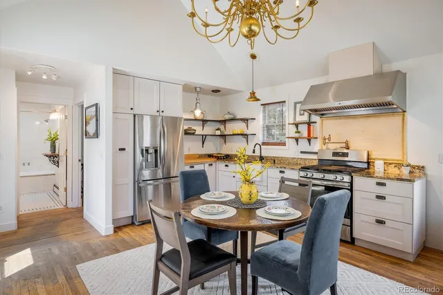 a kitchen with stainless steel appliances granite countertop a dining table and chairs
