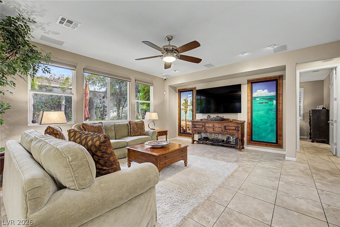 7415 Campbell Ranch Avenue Las Vegas, NV 89179 - Photo 12 of 52 Sun-filled living area featuring a ceiling fan and tiled floors for a comfortable ambiance.
