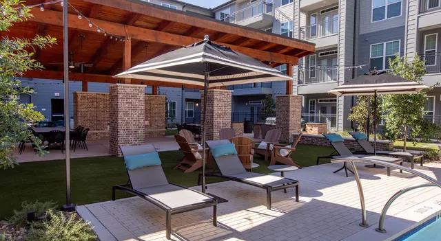 a view of a patio with a table and chairs under an umbrella