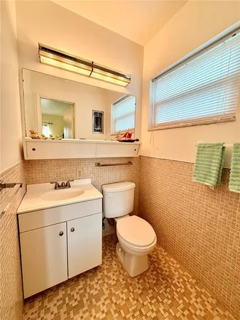 a bathroom with a toilet sink and mirror