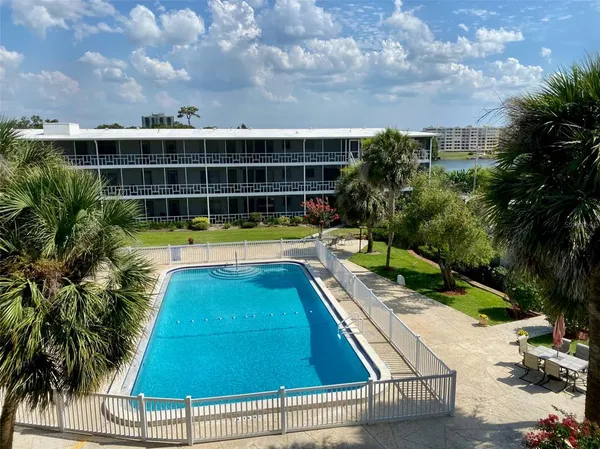 a view of swimming pool with lounge chair in front of house