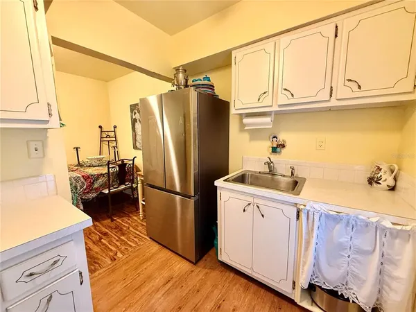 a kitchen with stainless steel appliances granite countertop a refrigerator a sink and white cabinets