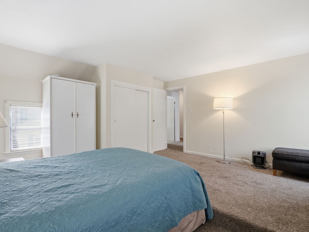 28 Court Street Lowell, MA 01852 - Photo 25 of 42 a spacious bedroom with a bed and a cabinets
