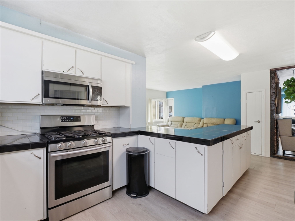 28 Court Street Lowell, MA 01852 - Photo 8 of 42 a kitchen with granite countertop a stove and a sink