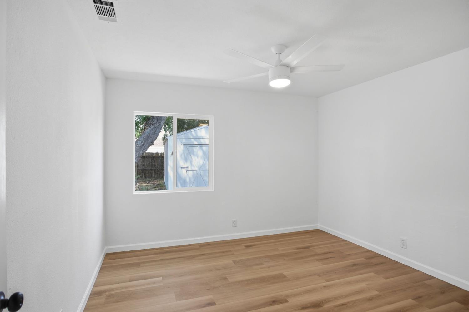 1451 Kent Way Modesto, CA 95355 - Photo 20 of 37 an empty room with wooden floor and windows