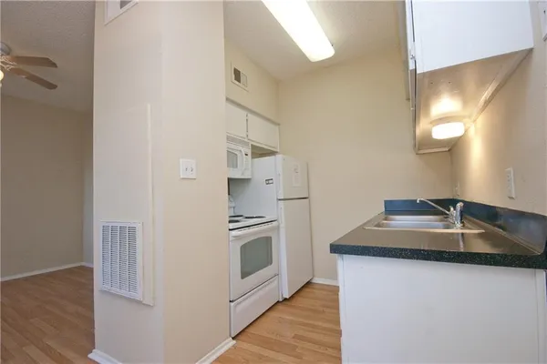a kitchen with stainless steel appliances granite countertop a sink and a refrigerator