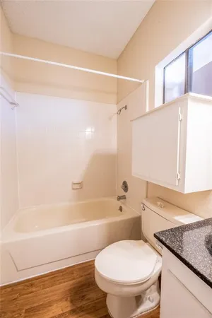 a bathroom with a granite countertop toilet sink and bathtub