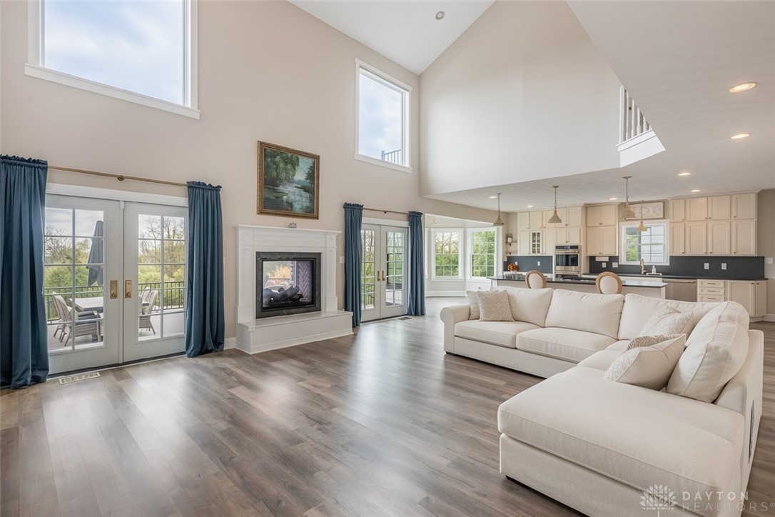 9586 Ferry Road Waynesville, OH 45068 - Photo 39 of 40 This airy living area features high ceilings, a fireplace, and an open-concept kitchen with deck access.