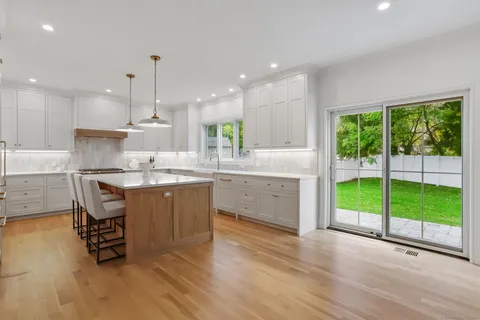 a kitchen with kitchen island a counter top space a sink stainless steel appliances and cabinets