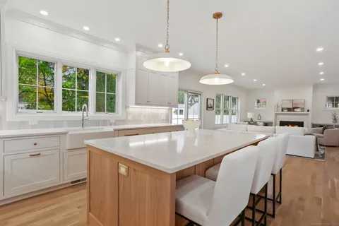 a kitchen with a stove a sink a dining table and chairs
