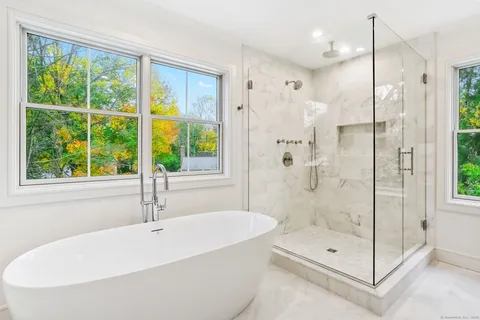 a white bath tub sitting next to a shower
