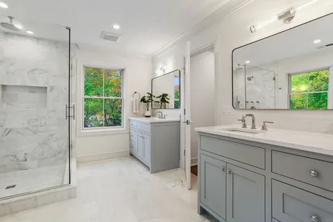 a bathroom with a granite countertop sink mirror and a bathtub