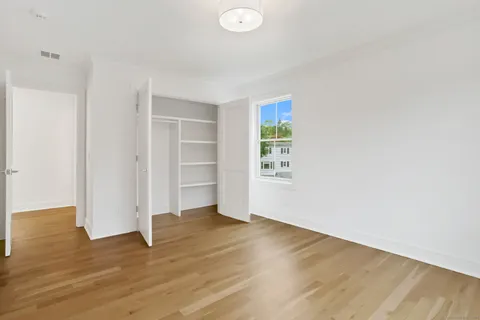 a view of an empty room with closet and a window