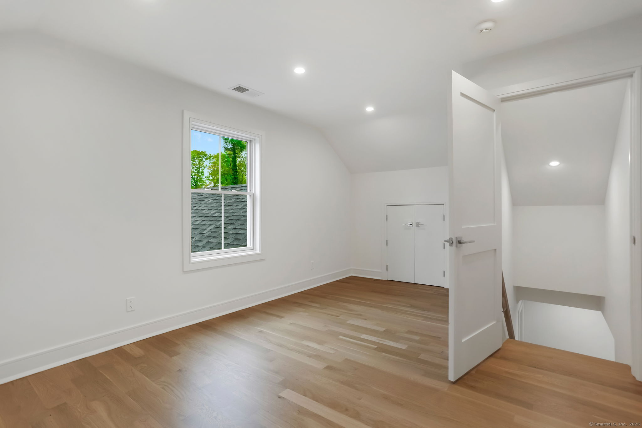 45 Robin Circle Fairfield, CT 06824 - Photo 32 of 40 an empty room with wooden floor and windows