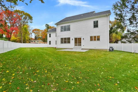 a front view of house with yard and trees in the background