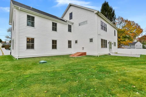 a view of a white house with a backyard