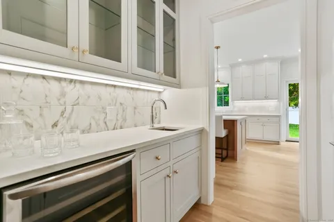 a kitchen with white cabinets and sink