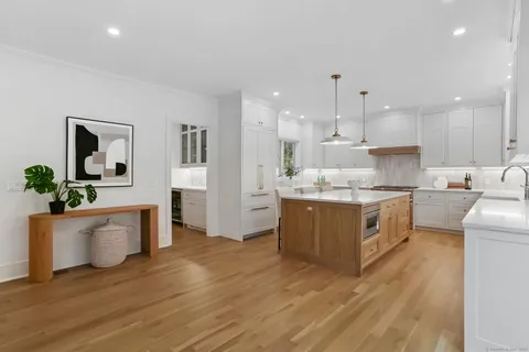 a kitchen with kitchen island white cabinets and stainless steel appliances
