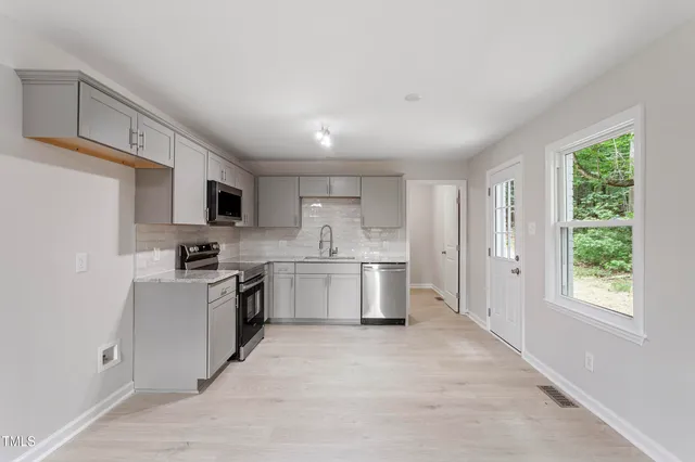 a kitchen with a sink a window and stainless steel appliances