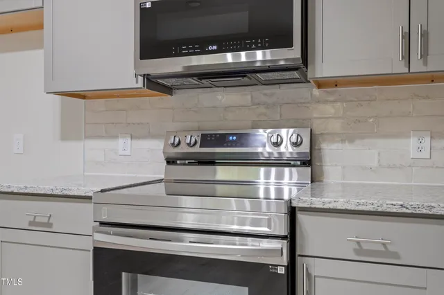 a kitchen with granite countertop cabinets stove and microwave