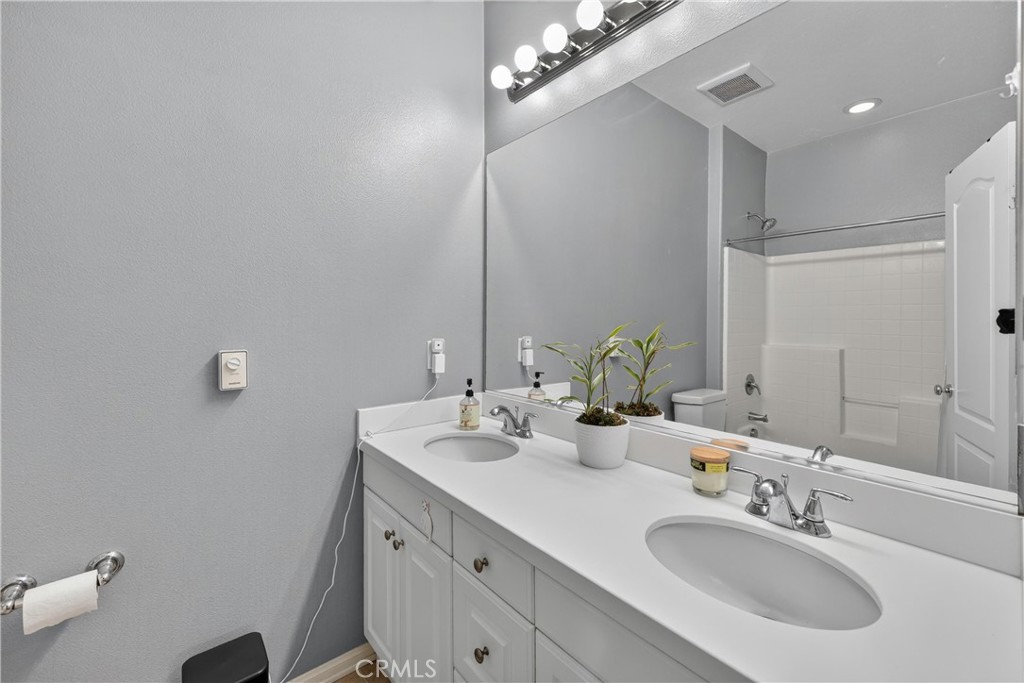 849 The Promenade, Unit D Azusa, CA 91702 - Photo 21 of 37 a bathroom with a double vanity sink and a mirror