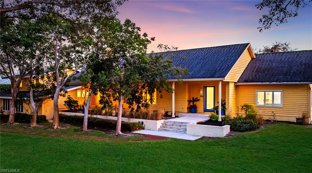 Back of property with roof with shingles, a yard, and a patio area