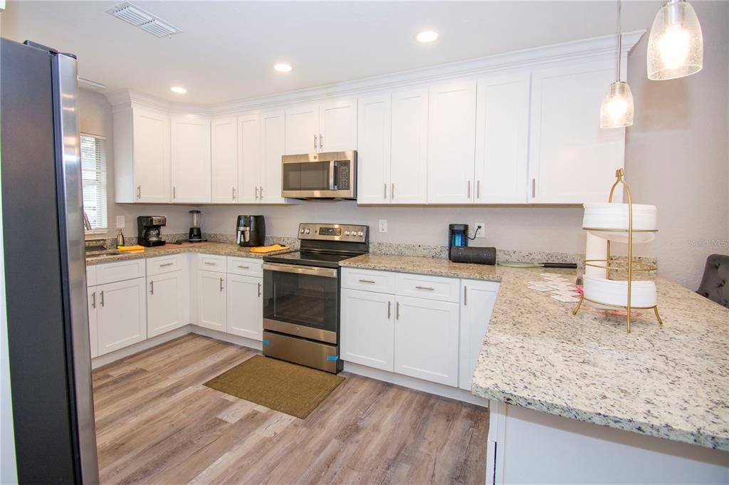 1504 Hallam Drive Lakeland, FL 33813 - Photo 14 of 34 a kitchen with a sink white cabinets and white appliances