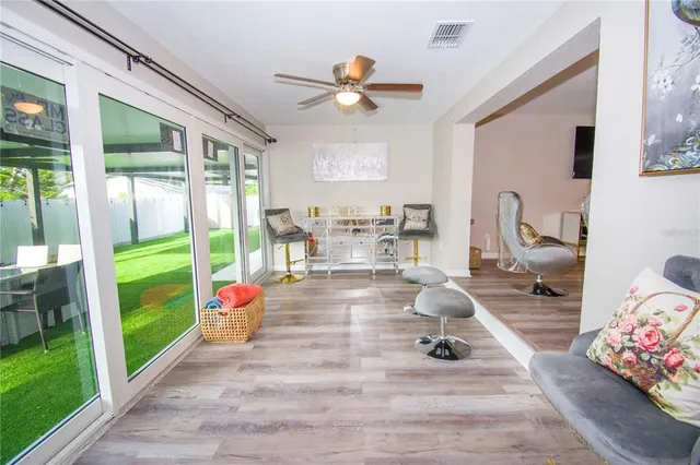 a living room filled with furniture hardwood floor and a floor to ceiling window