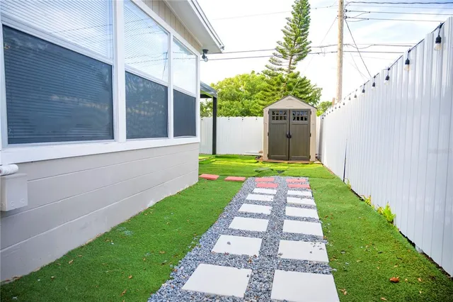 a front view of a house with a yard and potted plants