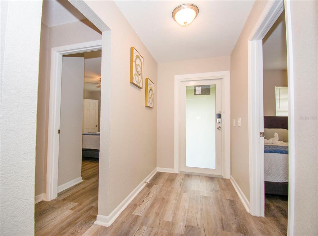 1504 Hallam Drive Lakeland, FL 33813 - Photo 3 of 34 a view of a hallway with wooden floor and a bathroom