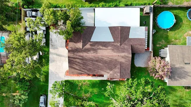 an aerial view of a house with a swimming pool a yard and a fountain
