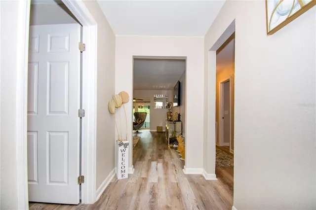 a view of a hallway with wooden floor fireplace and living room