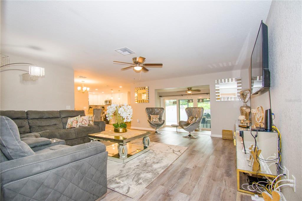 1504 Hallam Drive Lakeland, FL 33813 - Photo 5 of 34 a living room with couches and kitchen view with wooden floor