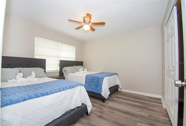 a spacious bedroom with two beds and painting on the wall