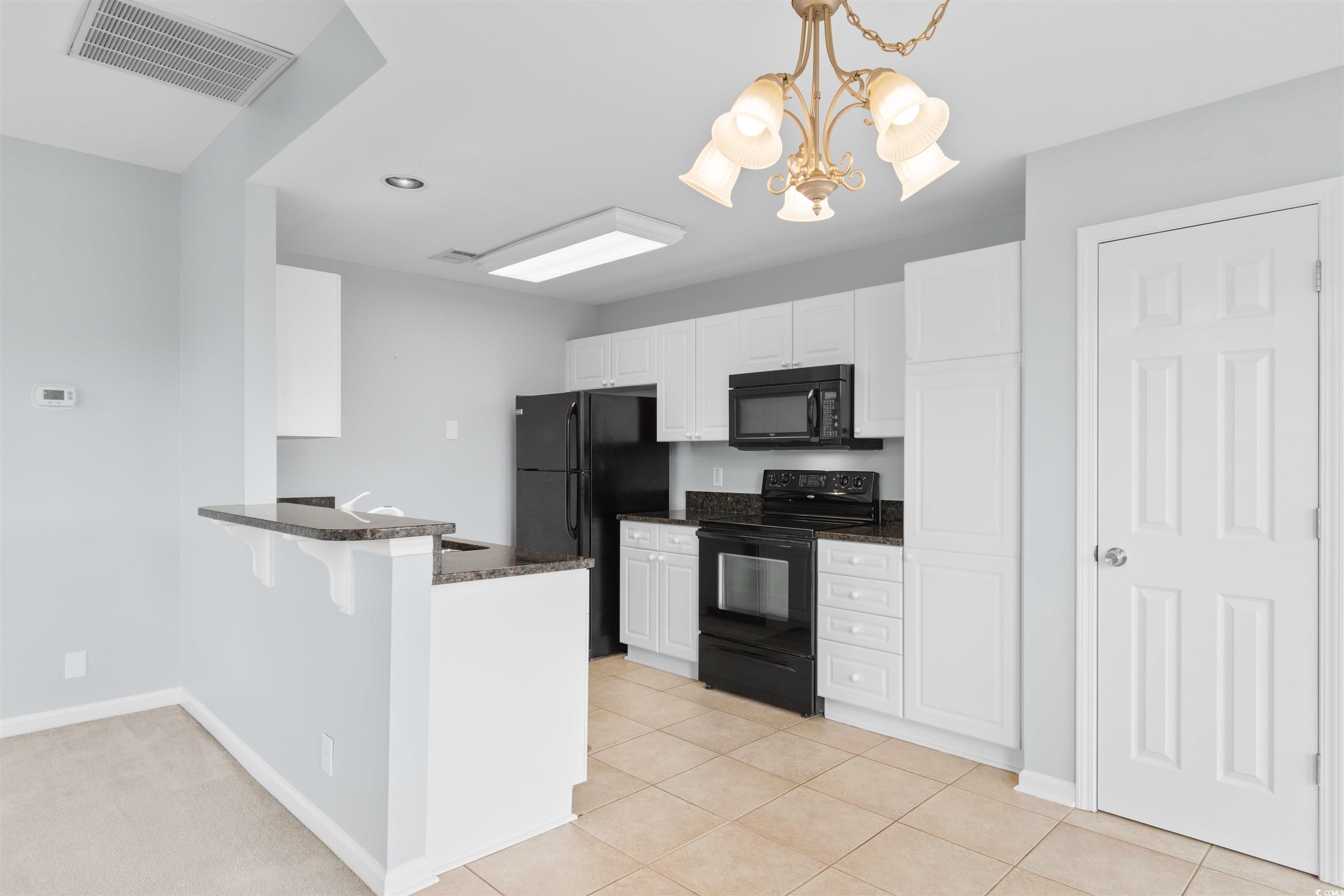 4430 Lady Banks Lane, Unit A2 Murrells Inlet, SC 29576 - Photo 6 of 31 Kitchen with black appliances, decorative light fixtures, a kitchen breakfast bar, white cabinetry, and a peninsula