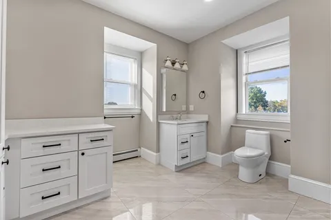 a bathroom with a toilet sink and a window