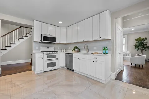 a kitchen with cabinets stainless steel appliances and wooden floor
