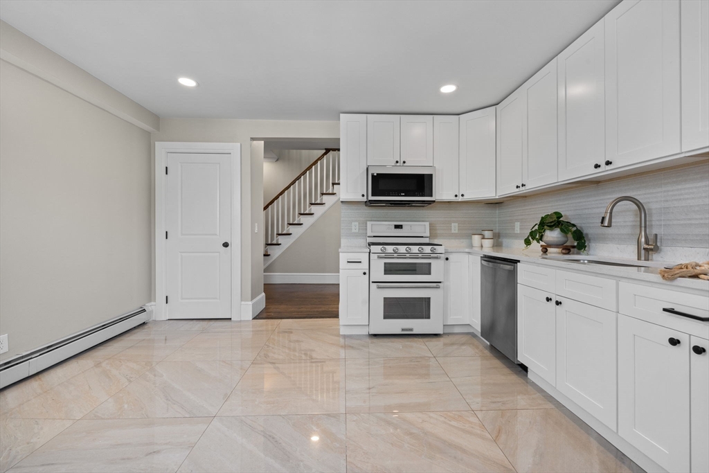 62 Chestnut Street, Unit 2 Saugus, MA 01906 - Photo 7 of 22 a kitchen with stainless steel appliances a stove sink and cabinets