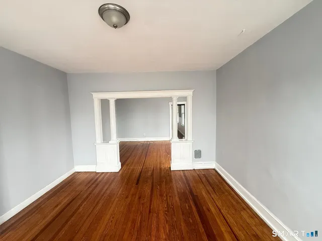 a view of empty room with wooden floor