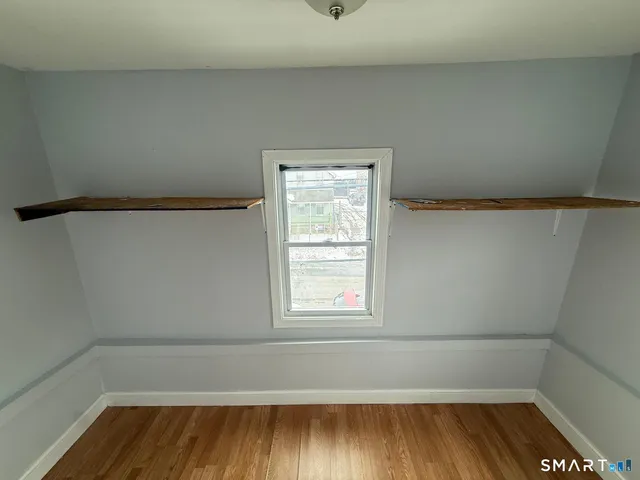 a view of a room with wooden floor and window