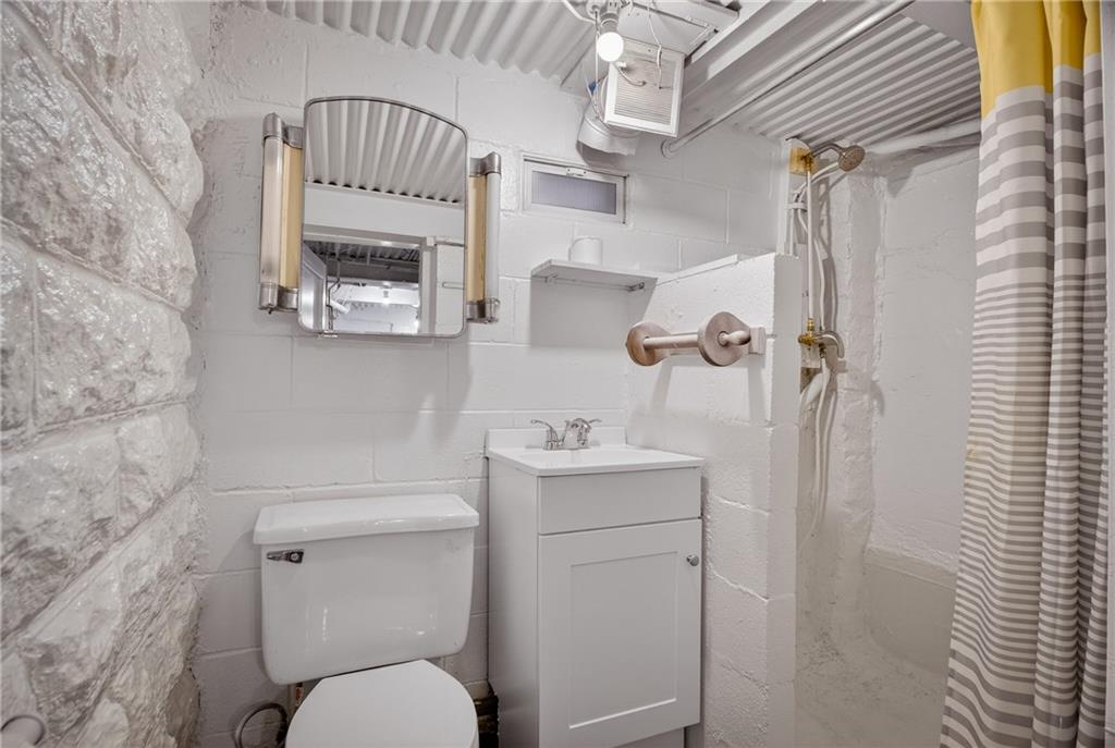 611 Montview Street Pittsburgh, PA 15214 - Photo 30 of 39 a bathroom with a toilet a sink and mirror