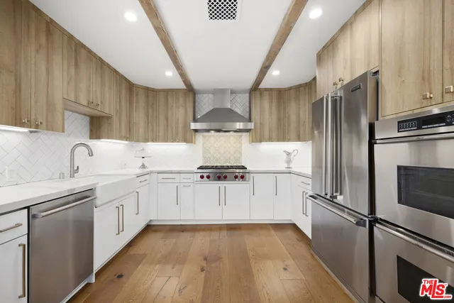 a kitchen with stainless steel appliances kitchen island granite countertop a refrigerator and a sink